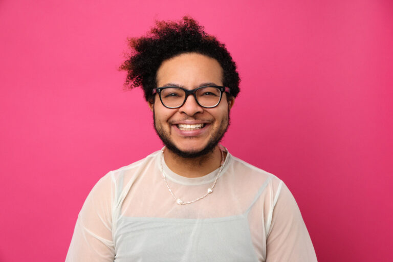 Portraitfoto einer Person vor pinkem Hintegrrund
